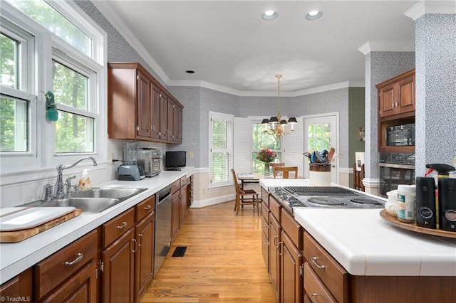 6516 Dornoch Dr, Greensboro, NC 27410 - kitchen with a sink, wallpapered walls, stainless steel appliances, light wood-style flooring, and ornamental molding