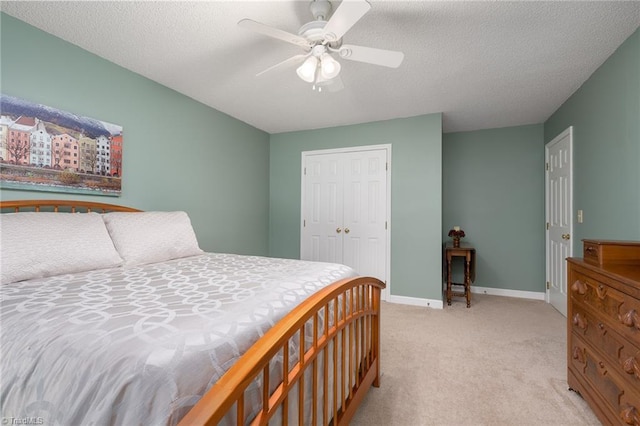 6516 Dornoch Dr, Greensboro, NC 27410 - bedroom featuring light colored carpet, a closet, baseboards, ceiling fan, and a textured ceiling