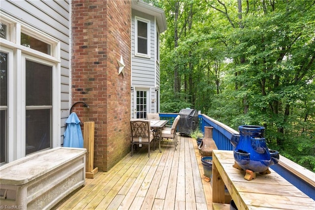 6516 Dornoch Dr, Greensboro, NC 27410 - wooden terrace with outdoor dining space, grilling area, and view of wooded area