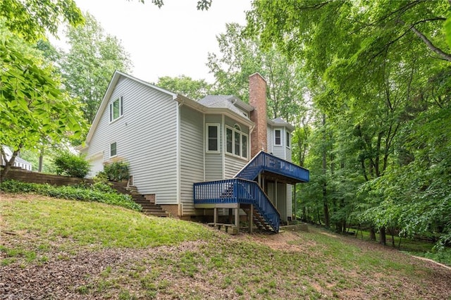 6516 Dornoch Dr, Greensboro, NC 27410 - rear view of house featuring stairway, a chimney, a wooden deck, and a lawn
