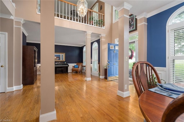 6516 Dornoch Dr, Greensboro, NC 27410 - entryway with decorative columns, ornamental molding, light wood-type flooring, a chandelier, and baseboards