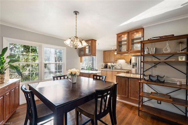 dining area with crown molding, dark hardwood / wood-style flooring, and a notable chandelier