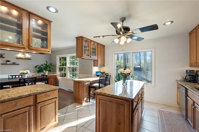 kitchen with a kitchen island, plenty of natural light, and stainless steel dishwasher