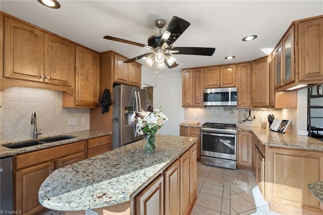 kitchen featuring sink, light tile patterned floors, backsplash, stainless steel appliances, and light stone countertops