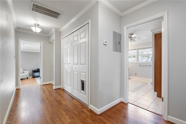 corridor featuring ornamental molding, light hardwood / wood-style floors, and electric panel