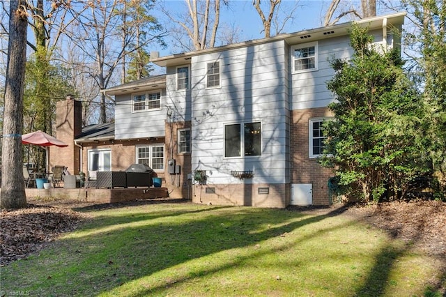 rear view of property featuring a lawn