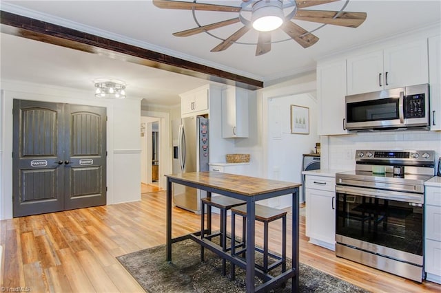 3412 Smithtown Rd, East Bend, NC 27018 - kitchen with appliances with stainless steel finishes, light wood-style floors, ceiling fan, white cabinetry, and tasteful backsplash