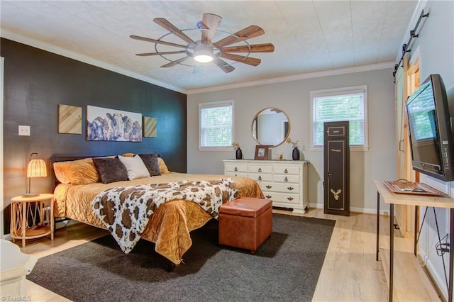 3412 Smithtown Rd, East Bend, NC 27018 - bedroom with light wood-style flooring, a barn door, crown molding, a ceiling fan, and baseboards