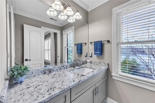 bathroom featuring a healthy amount of sunlight, visible vents, ornamental molding, and a notable chandelier