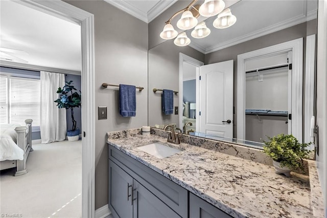 bathroom featuring ornamental molding, vanity, and baseboards