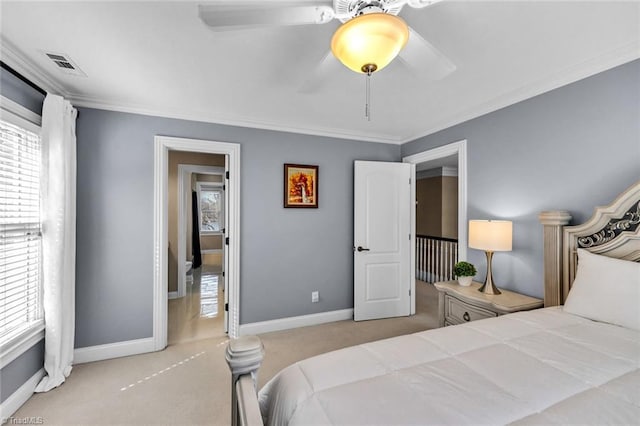 carpeted bedroom with crown molding, ceiling fan, visible vents, and baseboards