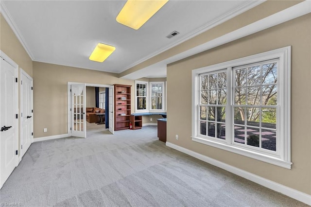 empty room with carpet floors, built in study area, and baseboards