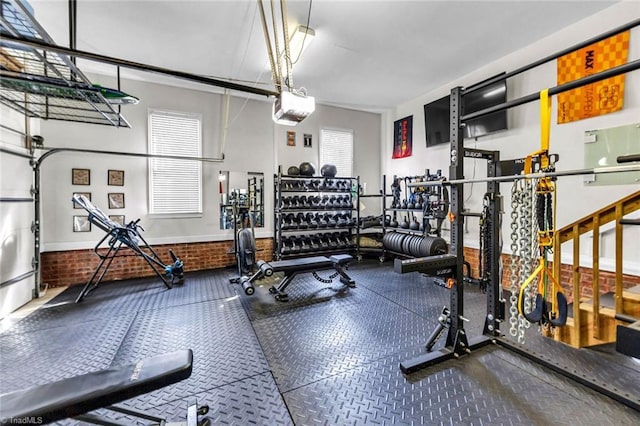 gym with a garage and brick wall