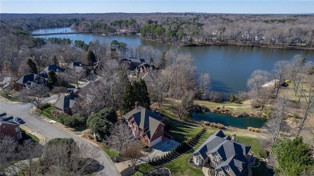 birds eye view of property featuring a water view and a wooded view