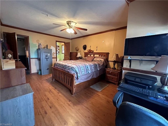 bedroom featuring hardwood / wood-style flooring, ceiling fan, crown molding, and a textured ceiling