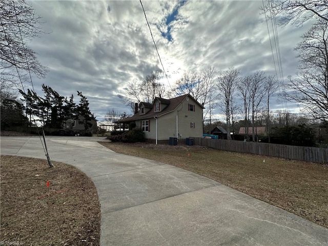 view of property exterior with central AC unit and a lawn