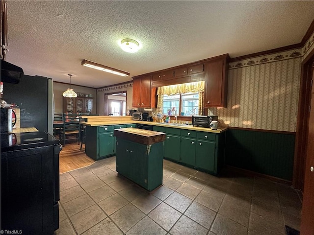 kitchen with stainless steel fridge, wooden counters, a textured ceiling, a kitchen island, and decorative light fixtures