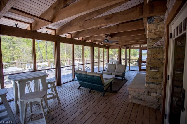 unfurnished sunroom with beam ceiling and ceiling fan