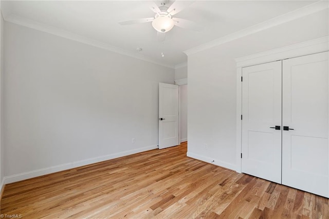 unfurnished bedroom with crown molding, light wood-type flooring, ceiling fan, and a closet