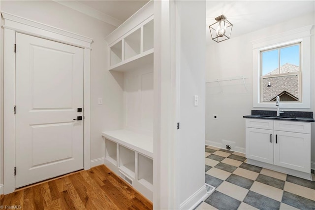 mudroom with crown molding, dark hardwood / wood-style flooring, and sink