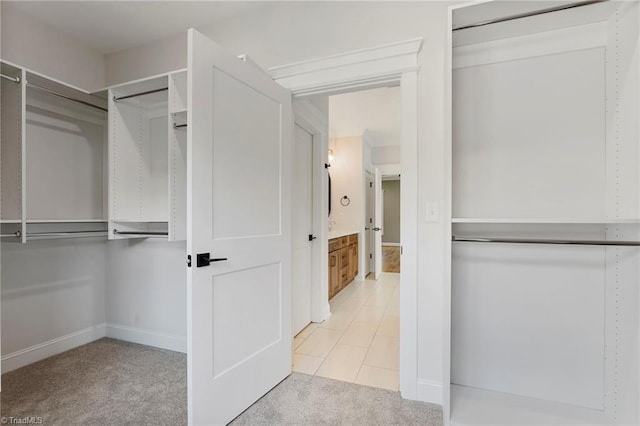 walk in closet with light tile patterned floors