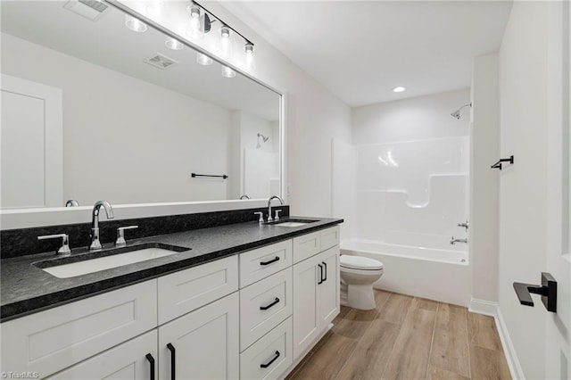 full bathroom with hardwood / wood-style flooring,  shower combination, toilet, and vanity