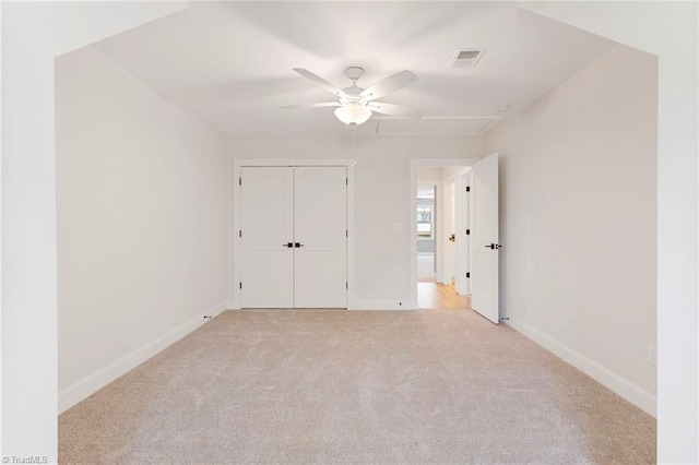 unfurnished bedroom with light colored carpet, ceiling fan, and a closet