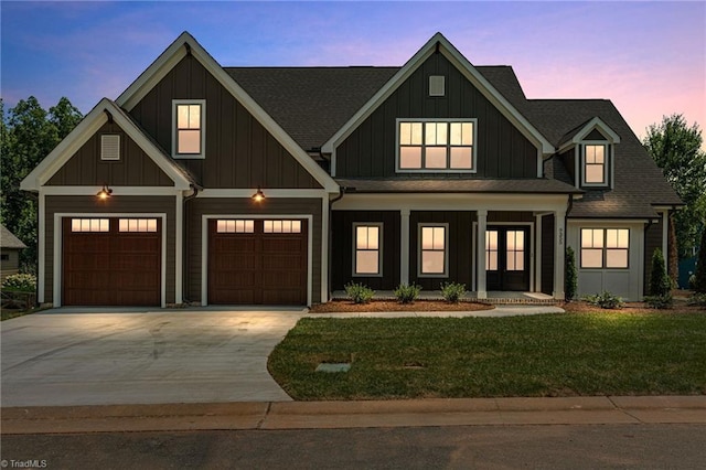 view of front of property with a garage and a lawn