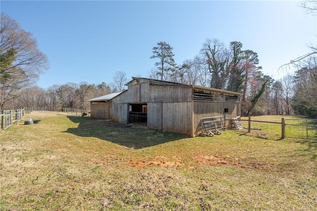 view of barn featuring a yard and fence