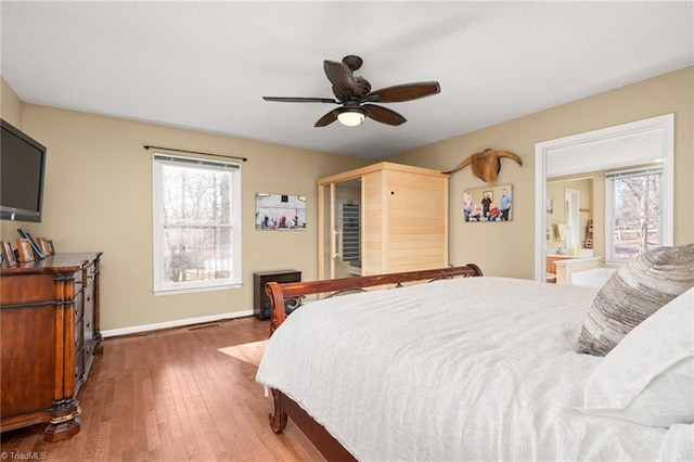 bedroom with a ceiling fan, baseboards, and wood-type flooring