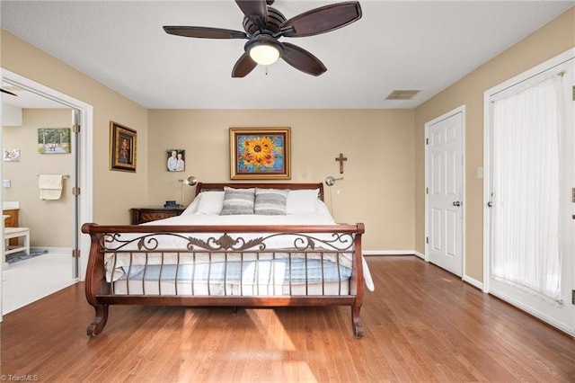 bedroom with visible vents, baseboards, and wood finished floors