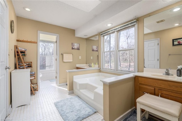 full bath featuring vanity, visible vents, baseboards, recessed lighting, and a bath