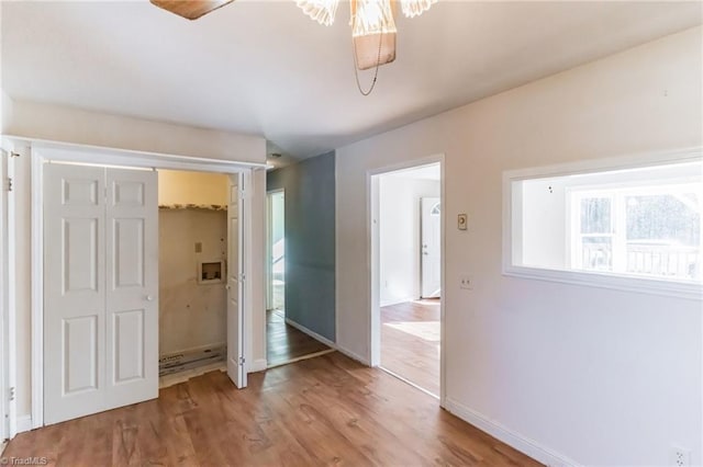 unfurnished bedroom featuring a closet, baseboards, and wood finished floors