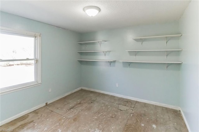 interior space featuring a textured ceiling and baseboards