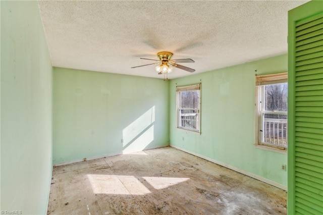 empty room with a textured ceiling and a ceiling fan