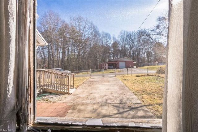 exterior space featuring an outbuilding, a gate, a detached garage, and fence