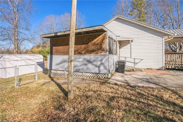 view of home's exterior featuring fence, metal roof, a patio, and a yard