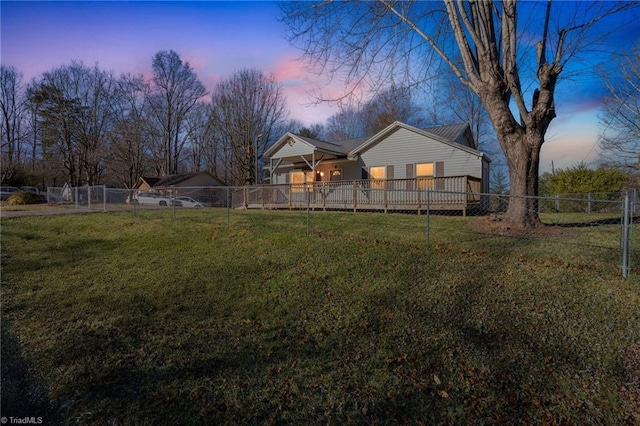 back of property at dusk featuring fence private yard and a yard