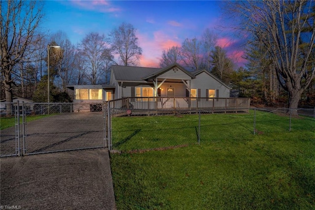 view of front of home with a yard, driveway, and fence