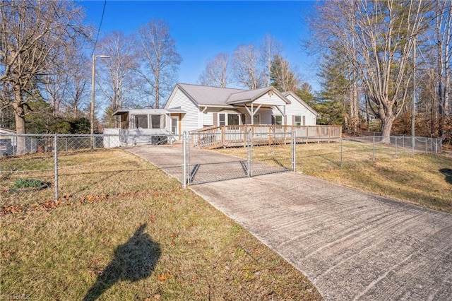 view of front of house with driveway, a front lawn, fence private yard, and a gate