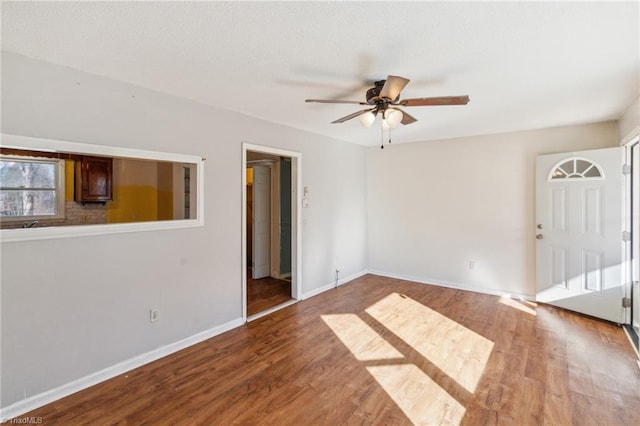 unfurnished room featuring a ceiling fan, baseboards, and wood finished floors