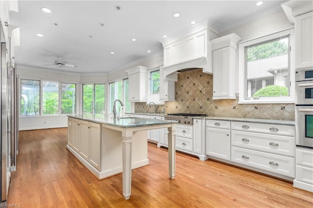 kitchen featuring custom exhaust hood, a ceiling fan, and crown molding