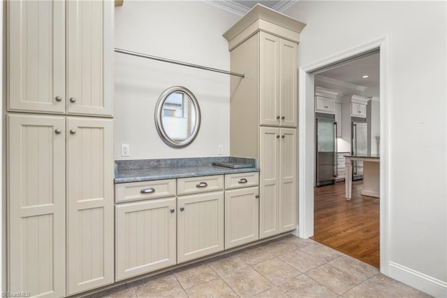 kitchen featuring stainless steel built in fridge, crown molding, cream cabinets, and light tile patterned floors