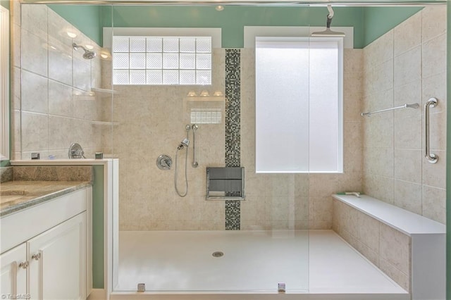 full bathroom with vanity and a tile shower