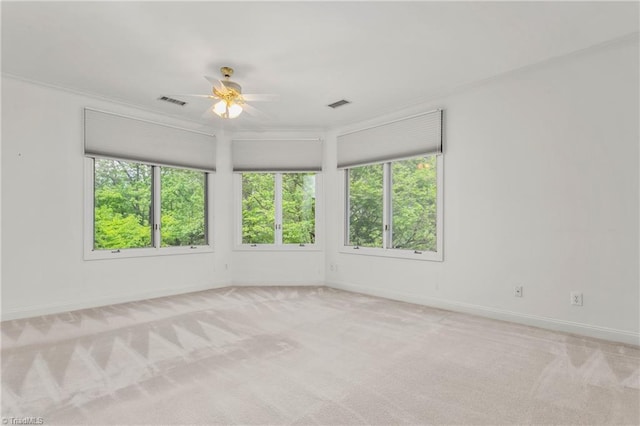 unfurnished room with crown molding, plenty of natural light, visible vents, and a ceiling fan