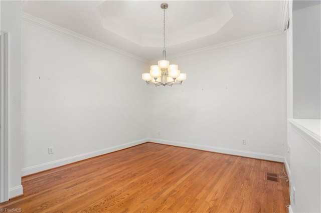 spare room featuring an inviting chandelier, visible vents, crown molding, baseboards, and light wood-style flooring