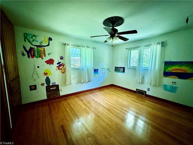 1024 Lone Hickory Rd, Yadkinville, NC 27055 - unfurnished room with healthy amount of natural light, wood finished floors, a ceiling fan, and baseboards