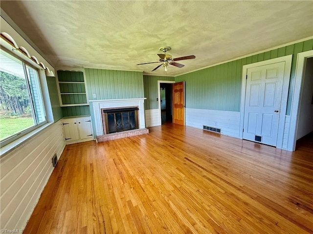1024 Lone Hickory Rd, Yadkinville, NC 27055 - unfurnished living room with light wood finished floors, a fireplace, ceiling fan, and wood walls