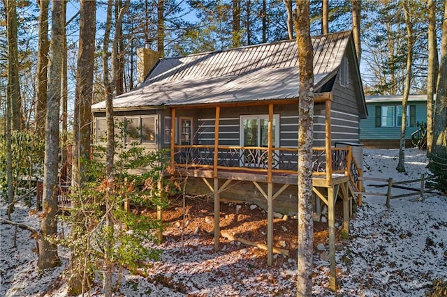 back of property featuring a deck, metal roof, a chimney, and fence