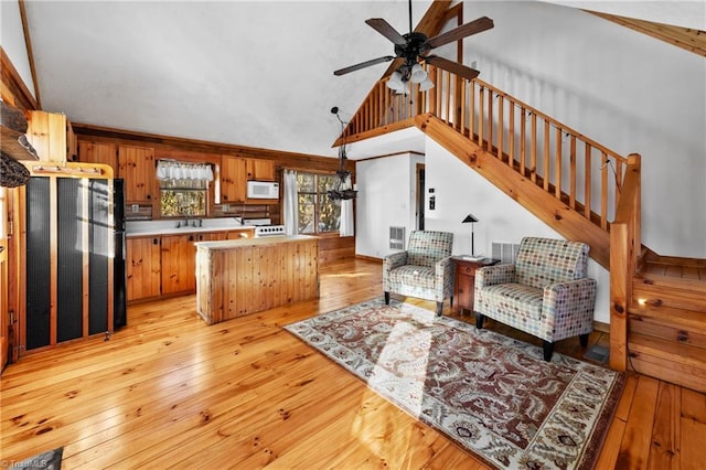 kitchen featuring white microwave, light wood-style flooring, light countertops, and a ceiling fan